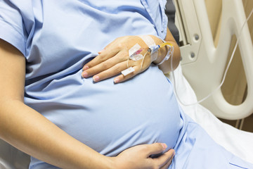 Asian Pregnant Woman patient is on drip receiving a saline solut