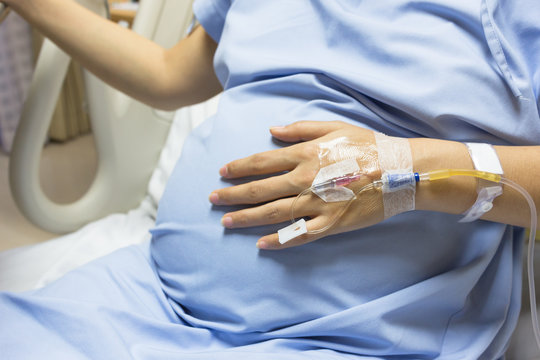 Asian Pregnant Woman patient is on drip receiving a saline solut