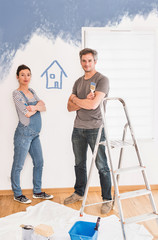  a pregnant woman and his husband painting the baby's bedroom