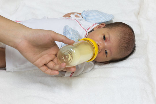 Asian Cute New Born Baby Eatting Mlik Mother In Bottle.