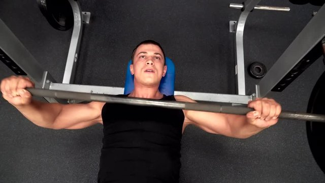 Athlete athletic barbell presses lying