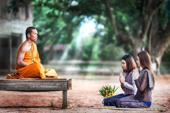 Two beautiful young woman pay-respect monks to achieve happiness.