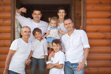 Portrait of happy handsome men on background of wooden house