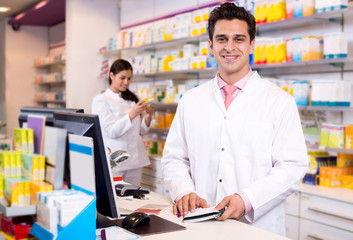 Portrait of pharmacist and assistant working