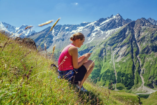  girl with mobile phone in the mountains