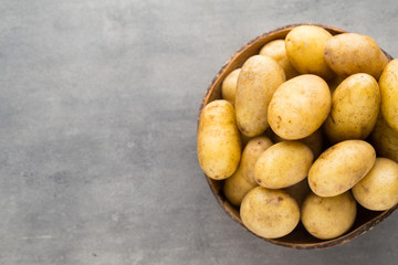 New potato on the bowl, gray background.