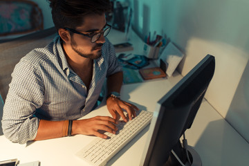 Portrait of male programmer using computer in a bright office.Late night.