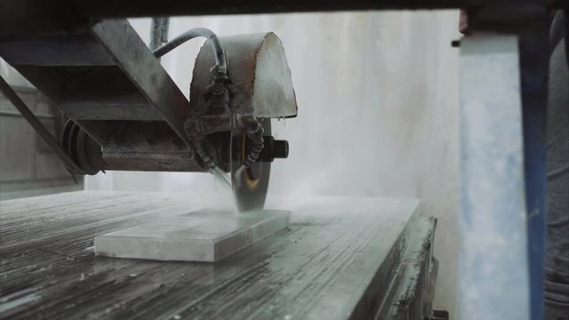 Saw machine makes a cross-section on the marble stone plate