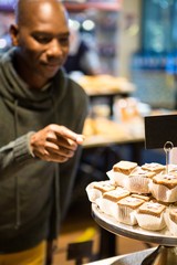 Smiling man purchasing sweet food