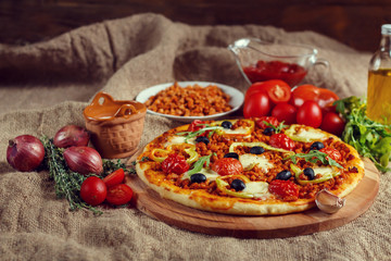 Pizza bolognese on a wooden board.