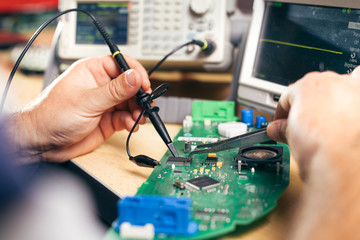 Repairman fixes electronic equipment in service center