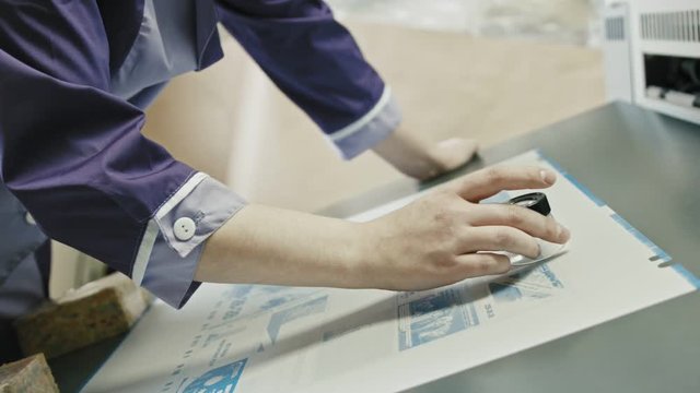 industrial printing process - worker monitors print quality,