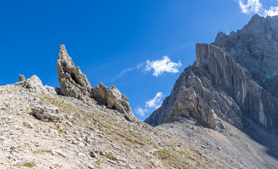 Alpenpass mit spitzen Felsen vor blauem Himmel