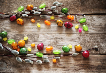Easter eggs with willow branches  on a wooden background
