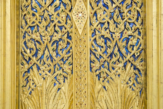 Close-up of intricate blue and gold detailing decorating a Buddhist temple in Bangkok Thailand