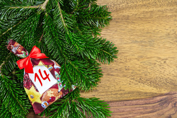 ein Weihnachtssäckchen mit roter Schleife liegen auf Tannenzweigen