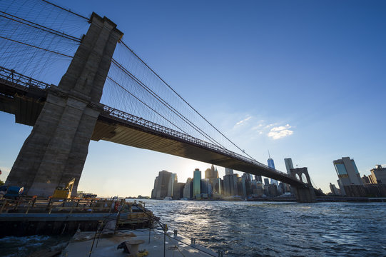 New York City skyline silhouette view of Brooklyn Bridge and Downtown Manhattan on bright summer afternoon