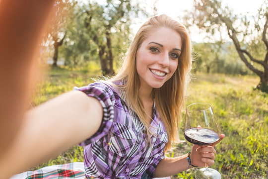Young Woman Taking Selfie on Mobile Phone while Drinking Red Win