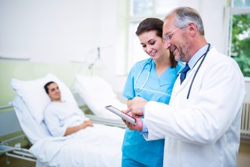 Doctor and nurse discussing on digital tablet