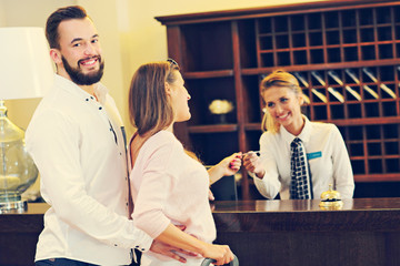 Couple at reception desk in hotel