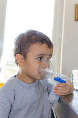 little boy using inhaler alone