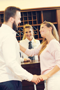 Couple at reception desk in hotel