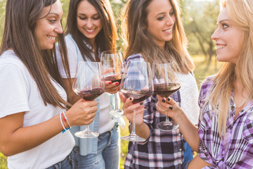 Smiling Girls Toasting with Red Wine Outdoors