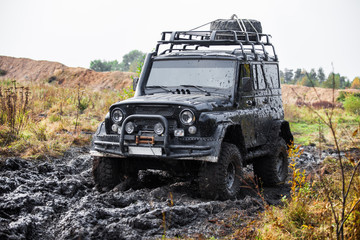 Russian black off road car UAZ in mud