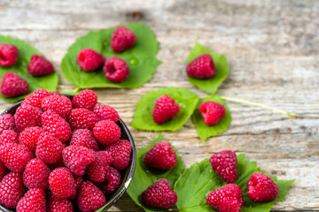 Fresh raspberries summer fruits harvest on wooden background