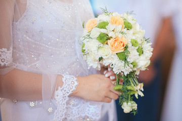 bridal bouquet of flowers in hands of the bride

