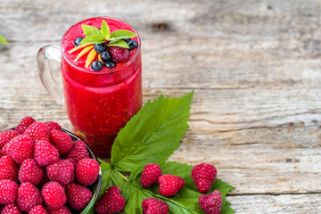 Raspberry smoothie in a glass jar, drink with fresh berries