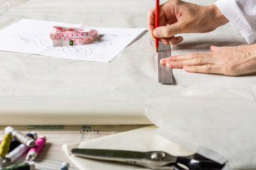 Seamstress is making patterns for clothes. Style and design development and creating garment,...