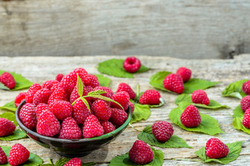 Fresh raspberries summer fruits in a bowl on wooden table