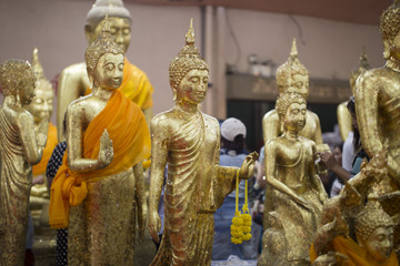 The image of a golden Buddha statue with gold leaf pasting multiple elements.