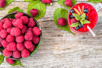 Raspberry smoothie on wooden table, overhead, copy space