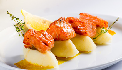 pieces of grilled salmon with boiled potatoes