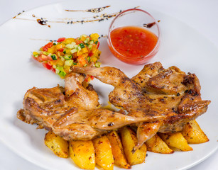 roasted quail on a baked potato with sauce