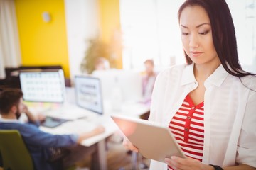 Fototapeta premium Confident businesswoman using digital tablet at creative office