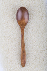 Rice and wooden spoon on the white