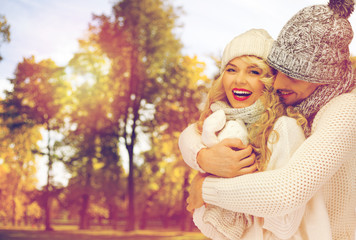 happy couple in warm clothes over autumn