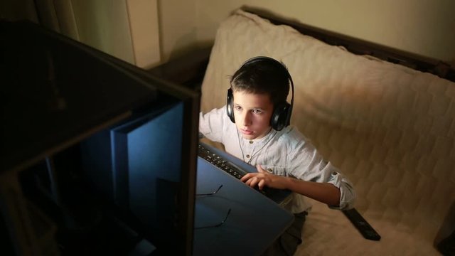 Teen boy plays games on the computer at night. Online Games