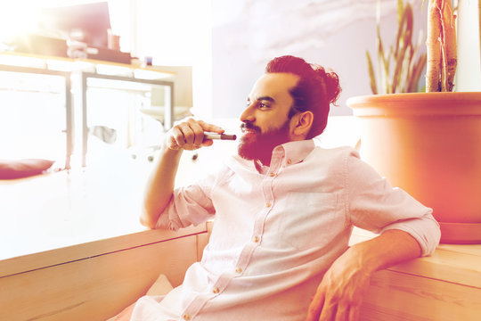 Smiling Man With Beard And Hair Bun At Office