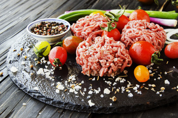 raw minced meat, vegetables with salt and spices, selective focus