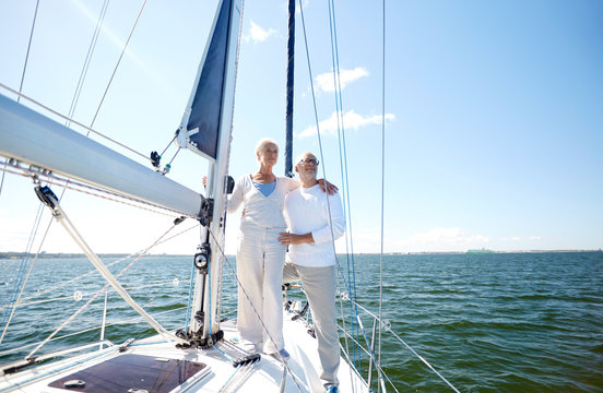 senior couple hugging on sail boat or yacht in sea