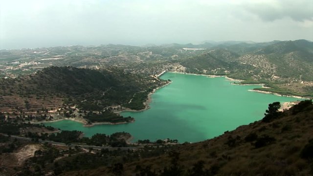Wide shoot from above of water reservoir "Embalse de Amadorio" in Orxeta, Spain. Shoot from nearby mountain.