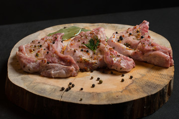 Raw pork ribs with spices, salt and rosemary on dark wooden background