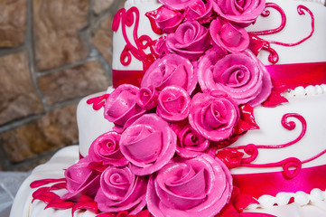 cake with cream flowers against the backdrop of a stone wall