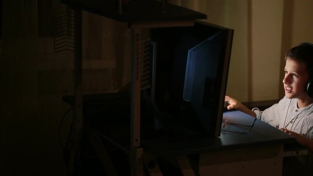 Teen boy plays games on the computer at night. Online Games