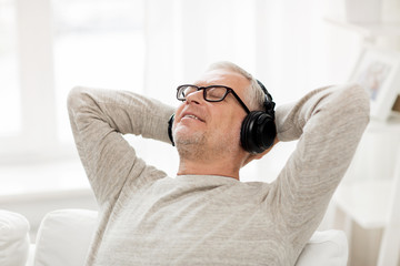 happy man in headphones listening to music at home
