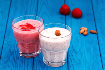 Strawberry and almond milk smoothies in a glass, blue background
